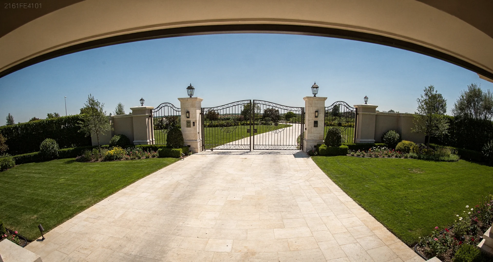 Security camera daytime view looking down the driveway of a luxury mansion from its elevated mounted position